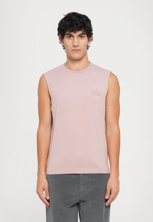 Light pink sleeveless t-shirt made from soft cotton, featuring a crew neckline and a small graphic detail on the chest. Paired with grey pants.