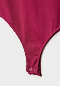 Bordo bodysuit z detalji, ki vključujejo gladko, elastično tkanino. Opozoriti je treba na dvojne zaponke in brezšivno zasnovo robov.