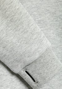 Hellgraue Sweatshirtärmel mit einem gerippten Bündchen und einem kleinen Ausschnitt. Der Stoff sieht weich mit einer leichten Textur aus.