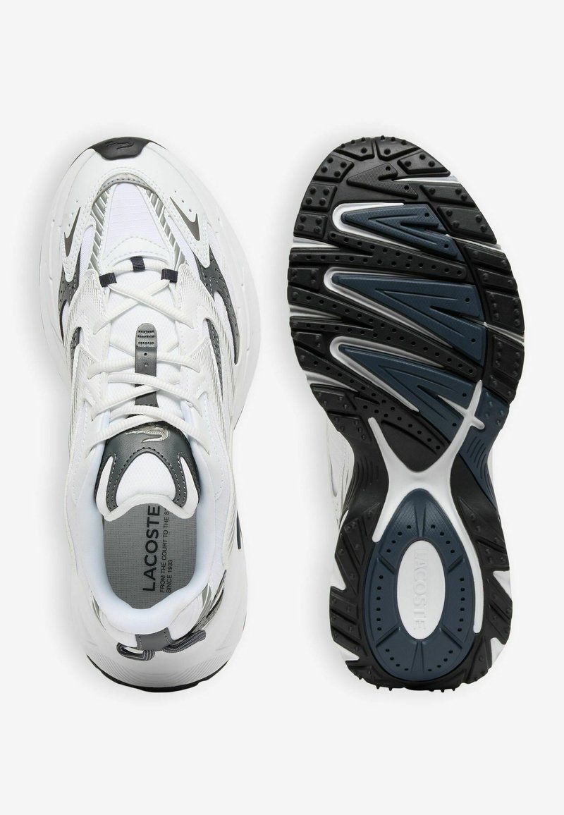 Paar weiße und graue Lacoste Laufschuhe, eins zeigt die Draufsicht und das andere die schwarze und graue strukturierte Sohle.