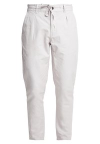 Pantalon gris clair en mélange de coton avec taille à cordon, jambe fuselée et poches latérales. Texture lisse et détails minimalistes.