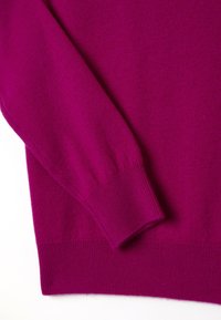 Magenta Pullover mit langen Ärmeln, gerippten Bündchen und Saum, aus weichem Strickstoff mit glatter Textur.