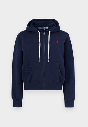 Sudadera con capucha azul marino con cremallera, cordones blancos, bolsillos delanteros, puños acanalados y logo rojo de Polo Ralph Lauren en el pecho.