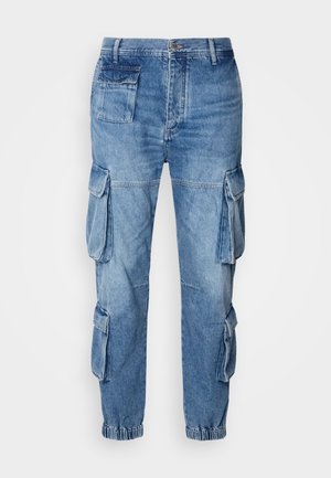 Pantaloni cargo in denim blu chiaro con multiple tasche laterali, polsini elasticizzati e una vestibilità relax, caratterizzati da dettagli di cucitura su tutta la superficie.
