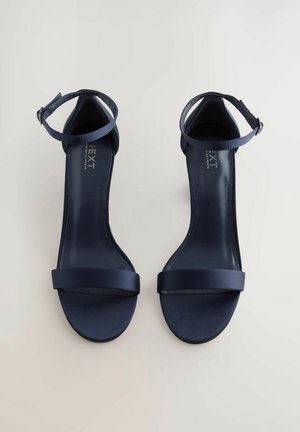 Jūras zila atklāto pirkstu sandale ar spīdīgu satīna apdari, plānu potītes jostu un plašu priekšējo joslu. Eleganta, minimālisma dizaina. Gumijas zole.