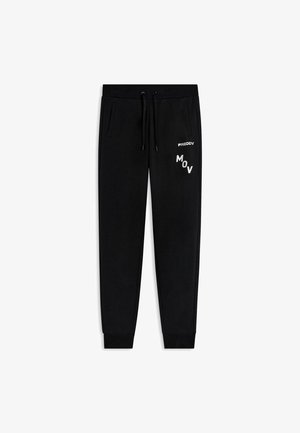 Pantaloni jogger neri con cintura elastica, cordino, tasche laterali, polsini a coste e logo bianco "FREDDY MOV" sulla gamba destra.