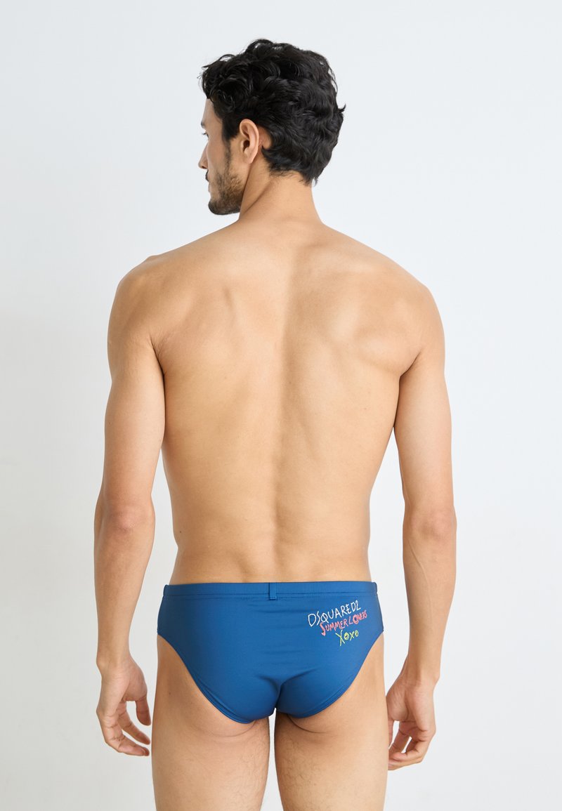Blaue Schwimmshorts mit glatter Textur, versehen mit besticktem Text auf der Rückseite. Entworfen für eine enge Passform.