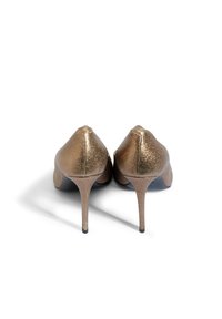 Złote metaliczne szpilki o gładkiej fakturze, w szpiczasty nosek i na obcasie typu sztylet. Charakteryzują się eleganckim, minimalistycznym wzornictwem.