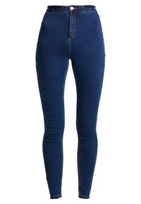 Jeans ajustados de tiro alto en denim azul oscuro con una textura suave, que cuentan con un cierre frontal de botón y detalles de costura mínimos.