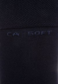Mustad ribatud sokid pehmest materjalist, millel on pealne riba heledamas toonis koos diskreetse logoga.
