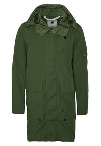 Grön, lång parkajacka med huva, flera fickor och dragkedjestängning fram. Tillverkad av hållbart, texturerat tyg.