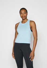 Lichtblauw mouwloos sporttop met een ronde hals, zachte stof en een ontspannen pasvorm, gecombineerd met zwarte leggings. Minimale uitstraling, geen patronen.
