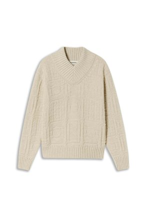 Cream-colored oversized sweater with a V-neck, featuring textured patterns and ribbed cuffs and hem. Made from soft, cozy material.