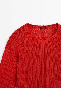 Pull rouge en maille avec une texture ajourée, col rond et manches longues. Présente un motif texturé et un design minimaliste.