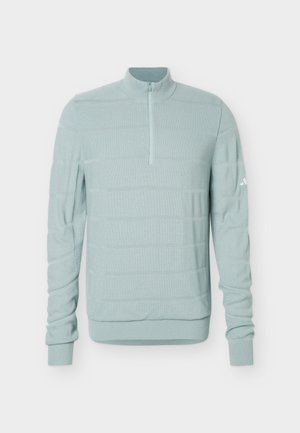 Lichtblauwe gebreide trui met een kwartritssluiting, geribbelde boorden en zoom, en een klein logo op de bovenste linker mouw.