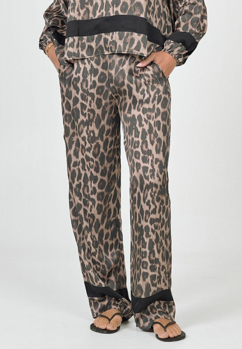 Lounge-outfit met luipaardprint in een zachte, gestructureerde stof. De top heeft een zwarte streep, en de broek heeft zwarte accenten aan de zoom.
