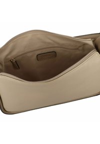 Beige leren handtas interieur, met een gladde textuur, een ritszakje en een subtiele logo-tag. Schoon en minimalistisch design.