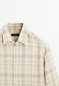 Camicia button-up beige chiaro con motivo a quadri dalle sottili righe marroni e colletto classico. Realizzata in tessuto traspirante.