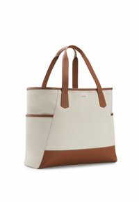 Sac cabas en toile beige avec des poignées, des garnitures et une base en cuir marron, doté de poches latérales et d'une forme rectangulaire structurée.
