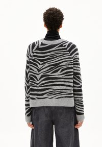 Grau-schwarzer Pullover mit Zebramuster aus Strick, Rundhalsausschnitt und gerippten Bündchen. Lockere Passform mit cropped Saum.