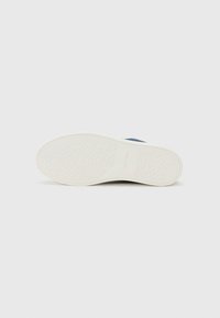 Calvin Klein sneakersåle i hvit gummi, med et sirkulært mønster og preget logo. Glatt, flat form uten bemerkelsesverdig hardvare.