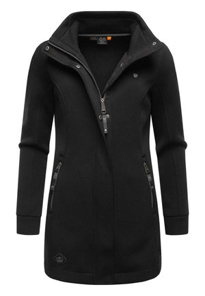 Chaqueta negra con cremallera, cuello alto, textura acanalada y bolsillos laterales. Presenta herrajes plateados y un parche de logo en el dobladillo.