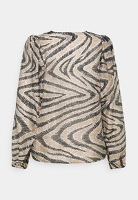 Blouse à manches longues avec motif abstrait en zigzag beige et noir, épaules bouffantes et poignets élastiques, vue de dos sur fond blanc.