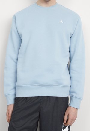 Sweatshirt bleu clair à col rond en matière douce. Présente des poignets et un ourlet côtelés, avec un logo Jordan blanc sur la poitrine gauche.