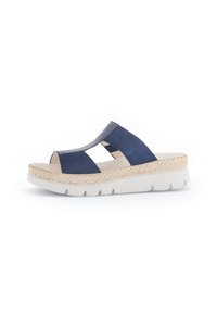 Navy blue suede sandals with a woven, beige platform sole. Open toe design features cut-out sections and elastic accents for flexibility.