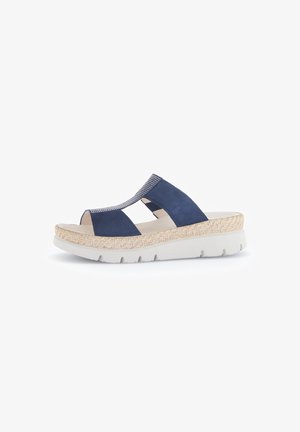 Navy blue suede sandals with a woven, beige platform sole. Open toe design features cut-out sections and elastic accents for flexibility.