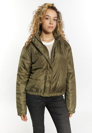 Olijfgroene, cropped pufferjack met een glanzende textuur, drukknopen en een hoge kraag. Model draagt een gestreept shirt en zwarte jeans.