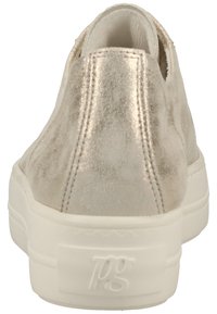 Scarpa slip-on beige metallica con texture liscia, suola bianca e dettagli di cucitura discreti sul retro. Presenta un emblema del marchio sul lato.