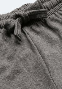 Graue Strick-Pyjama-Shorts mit einem elastischen Bund und einem Stoffzugband sowie einer weichen, strukturierten Oberfläche. Es sind keine Taschen sichtbar.