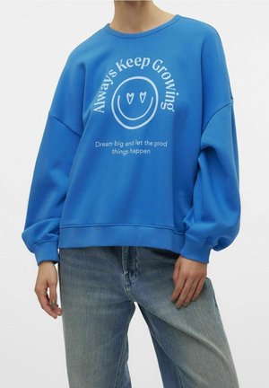 Sweatshirt bleu avec un col rond, des manches oversized, et un imprimé de texte graphique blanc avec un smiley. Matériau en mélange de coton doux.