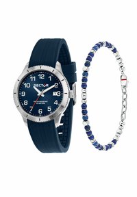 Orologio con cinturino in silicone blu, cassa in acciaio inossidabile con finitura argentata, indicatori delle ore bianchi, oblò per la data; affiancato da un bracciale di perline blu con dettagli argentati.