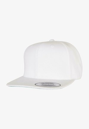 Gorra snapback blanca con visera plana y una tela texturizada, que presenta una etiqueta redonda en el frontal con detalles de la marca en texto negro.