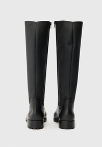 Botas de borracha pretas até ao joelho com um acabamento liso, fechos laterais e uma sola robusta. Design minimalista sem padrões ou detalhes visíveis.