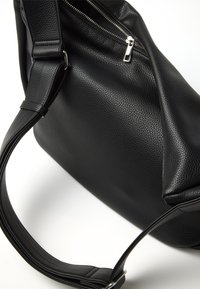 Borsa a mano in pelle nera con finitura texturizzata, dotata di chiusura con cerniera e una tracolla regolabile per maggiore versatilità.