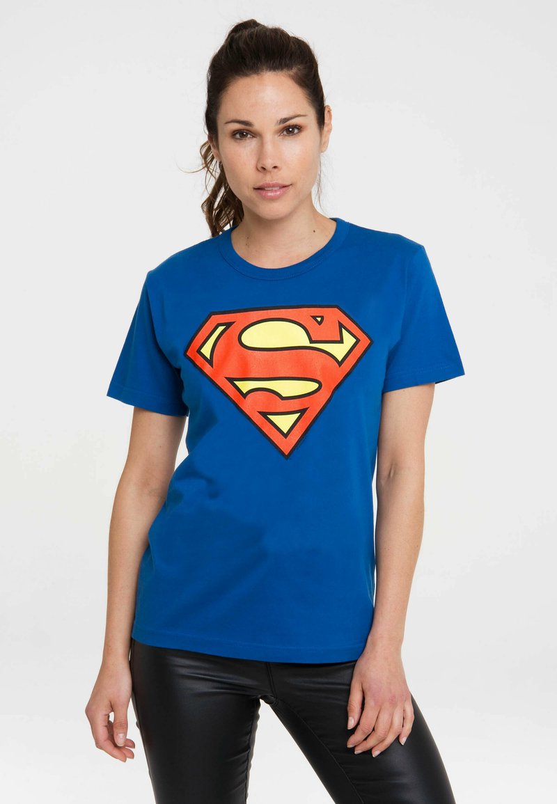 Blue cotton t-shirt featuring a large red and yellow Superman logo on the front. Short sleeves and a round neckline.