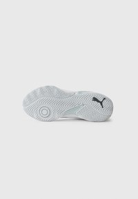 White rubber shoe sole with chevron tread pattern and a black Puma logo near the heel on a plain background.