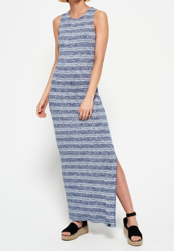 Robe maxi sans manches bleue et blanche à rayures avec fente sur le côté, portée avec des sandales à plateforme noires par une personne debout.