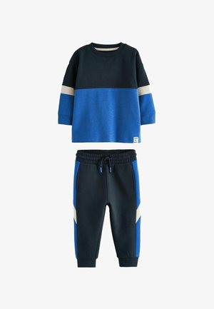 Two-piece set with a navy and blue color scheme. The top features a block design with a grey stripe. The pants have side pockets and elastic cuffs.