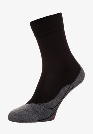 Schwarze Socke mit geripptem oberen Teil, grauen Fersen- und Zehenbereichen, die eine glatte Textur und subtile rote Akzente am Rand aufweist.