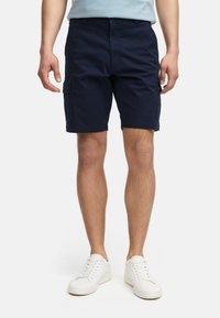 Tengerészkék cargo nadrág, pamut keverékből készült szövetből. Gombos záródás, oldalsó zsebek és laza fazon jellemzi. Minimalista design.