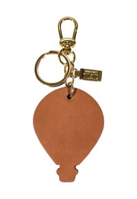 Portachiavi in pelle marrone a forma di mongolfiera con anello in metallo dorato, gancio e un piccolo cartellino rettangolare attaccato.