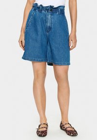 Zilā džinsu šorti ar augstu jostasvietu, savācamu jostas joslu un sānu kabatām. Iespējots neapstrādāts malums un klasiskā pogu aizdare.