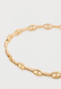Náramok zo zlatistého kovu s oválnymi článkami a malými priesvitnými rhinestones, s hladkým, lesklým povrchom a otvorenými časťami v dizajne.