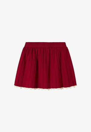 Red pleated skirt with a ribbed waistband and scalloped white hem detail, made of textured fabric.