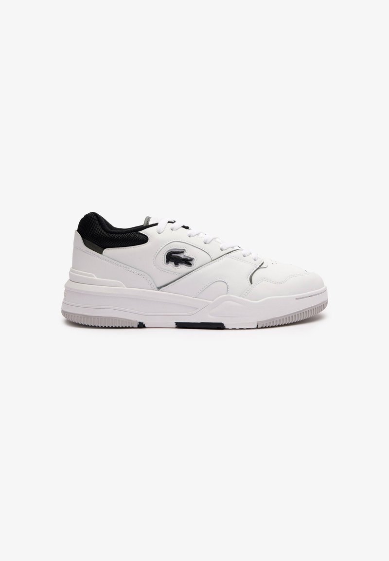 Baltās sneakers ar melniem akcentiem, sintētisks materiāls, apaļa purngala forma, sasienamais dizains, teksturēta virsma un gumijas zole ar saķeres rakstu.