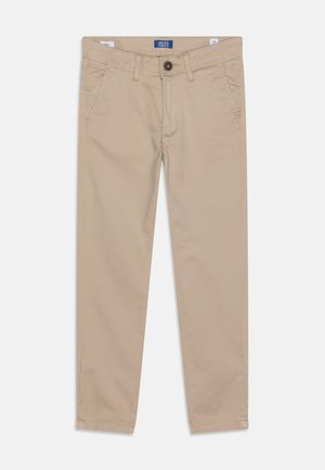 Beżowe chinosy w slim fit z przednimi kieszeniami, szlufkami na pasek i zapięciem na guzik, leżące płasko na białym tle.